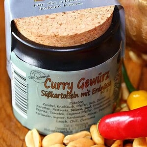 Gewürzregal mit Curry-Gewürz, Chili, Ingwer und weiteren Gewürzen.