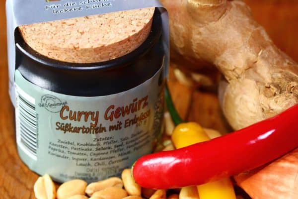 Gewürzregal mit Curry-Gewürz, Chili, Ingwer und weiteren Gewürzen.
