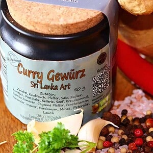Gewürzregal mit Gewürzgläsern und frischen Zutaten Gewürzregal mit Gewürzgläsern, Paprika, Knoblauch und Pfefferkörnern.