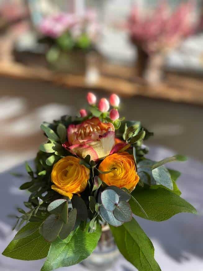 Blumenarrangement mit Rosen, Eukalyptus und pinken Blüten.