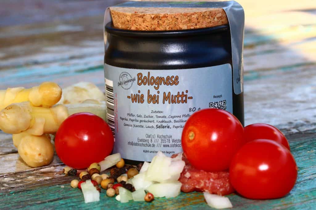 Bolognese in Keramiktopf mit frischen Tomaten und Gewürzen.